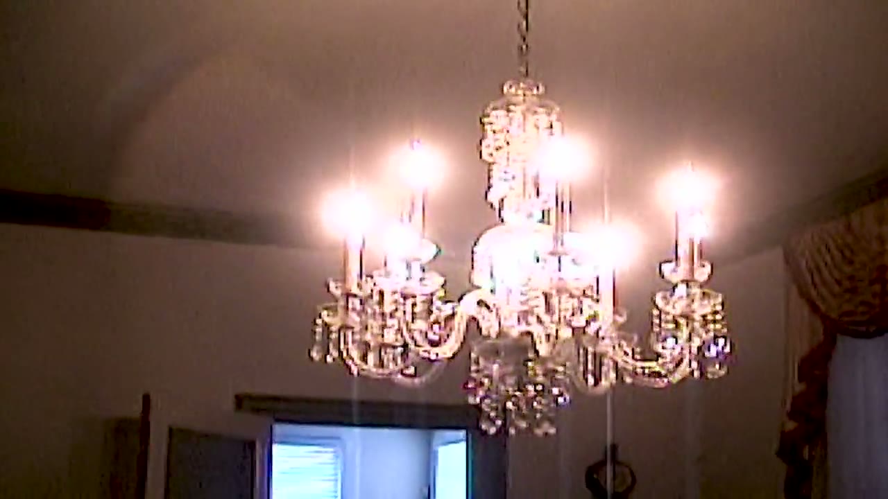 A warm chandelier frame from Chloe and Dan's wedding film